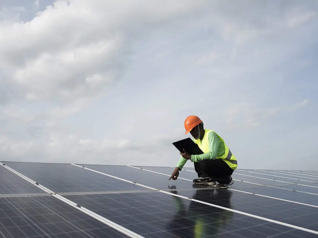 Technicien contrôlant une installation de panneaux solaires sur une toiture